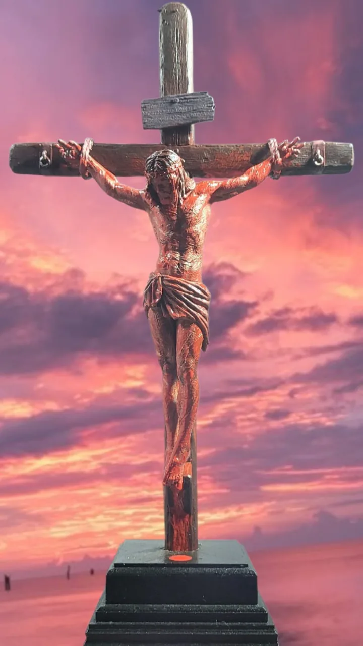Crucifixo policromado com o corpo de Cristo em tons de bronze sobre a cruz de madeira escura, sobre base preta