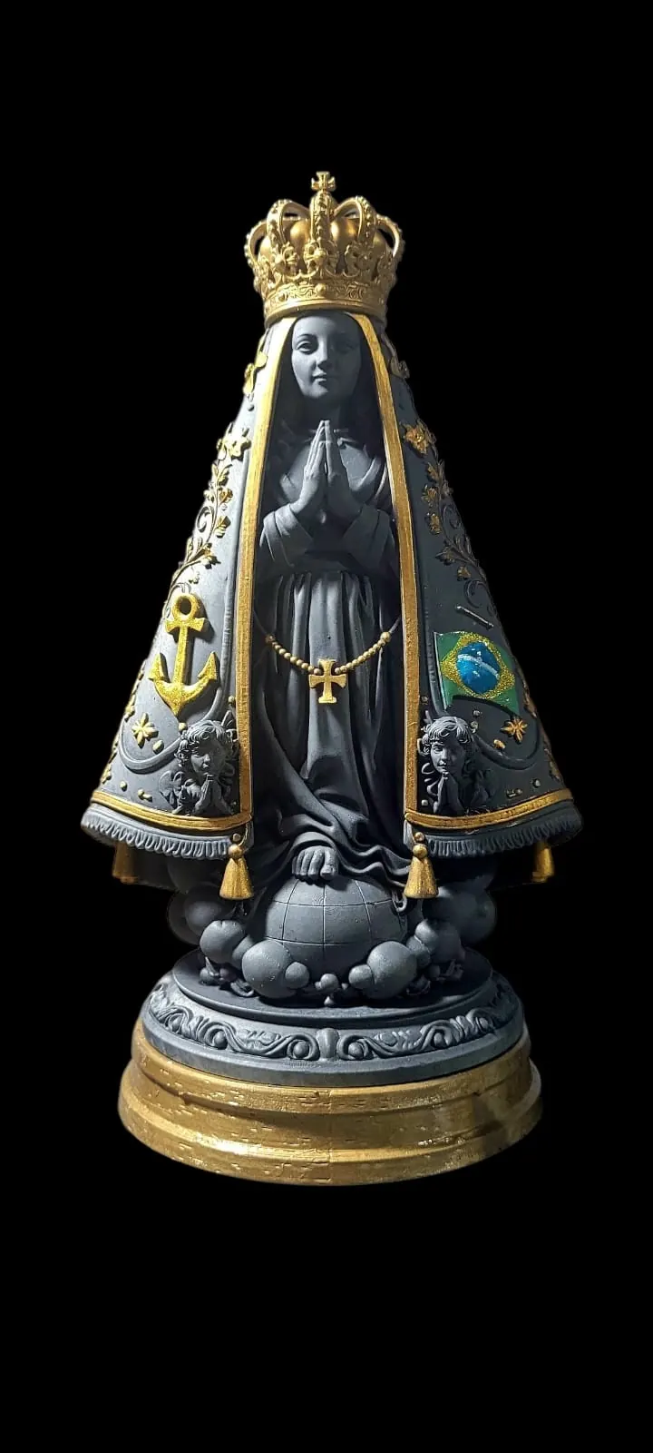 Imagem de Nossa Senhora Aparecida em cinza escuro com coroa e detalhes dourados, manto com âncora e bandeira do Brasil, sobre base dourada em fundo preto