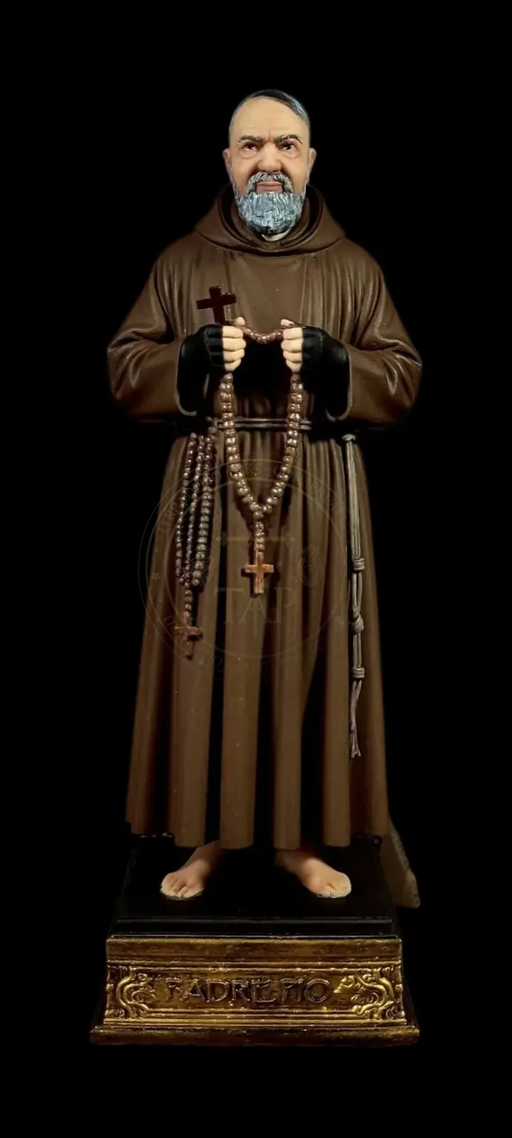 Imagem policromada de São Pio de Pietrelcina em hábito capuchinho marrom, com as mãos enluvadas segurando o rosário e uma cruz, sobre base dourada com a inscrição Padre Pio