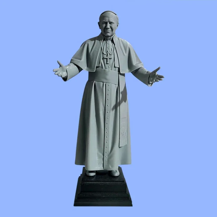 Estátua impressa em 3D de São João Paulo II de braços abertos, com cruz peitoral, em resina cinza sobre base preta