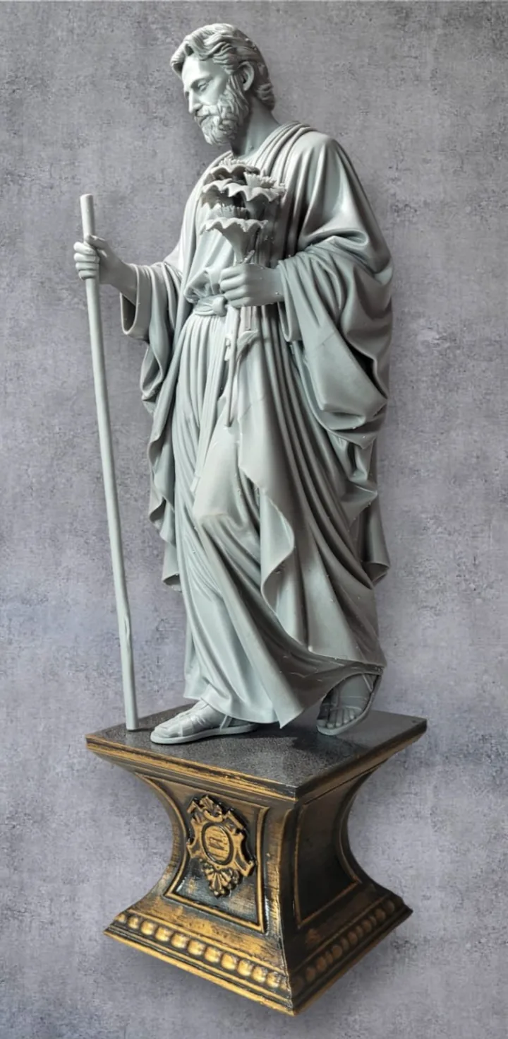 Estátua em resina cinza de São José segurando o cajado e o ramo de lírios, sobre pedestal dourado ornamentado